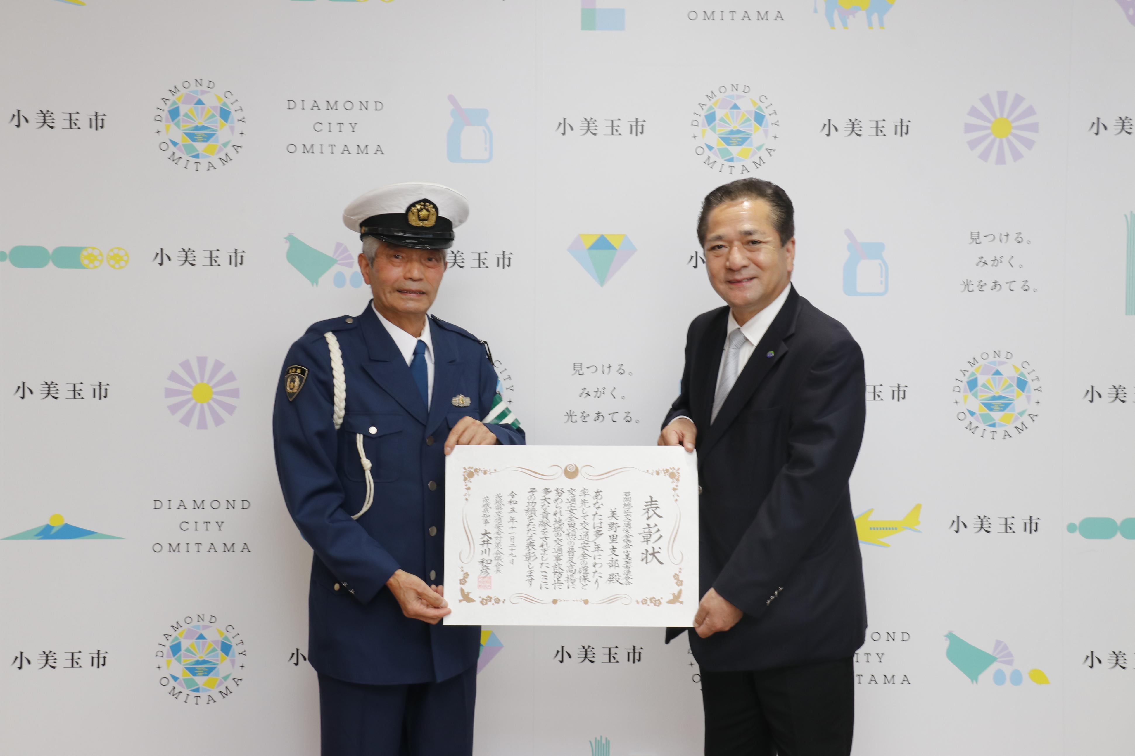 表彰状を持つ市長