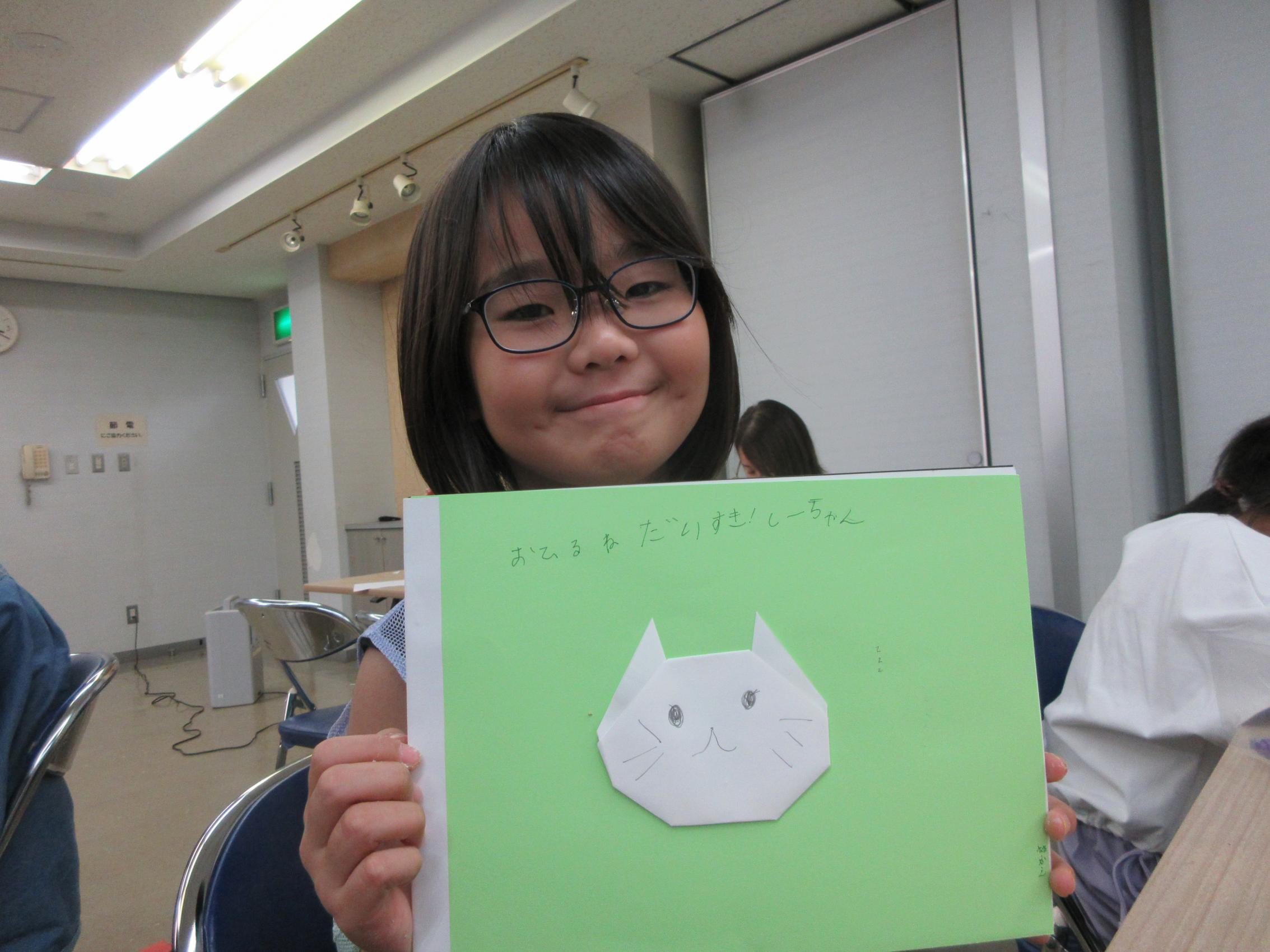 白いねこの絵本を見せてくれる参加者